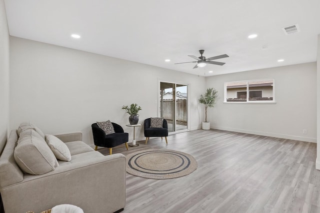 living room featuring visible vents, baseboards, a ceiling fan, light wood-style flooring, and recessed lighting