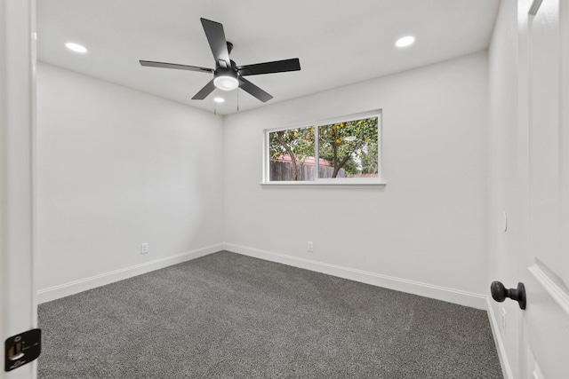 spare room featuring baseboards, dark carpet, and recessed lighting