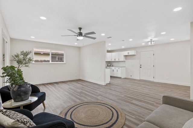 living area featuring recessed lighting, visible vents, light wood-style flooring, a ceiling fan, and baseboards