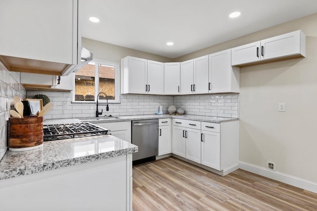 kitchen featuring light wood-style flooring, white cabinetry, baseboards, stainless steel dishwasher, and light stone countertops