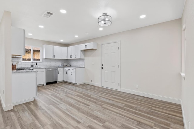 kitchen featuring light wood-style flooring, visible vents, light countertops, decorative backsplash, and dishwasher