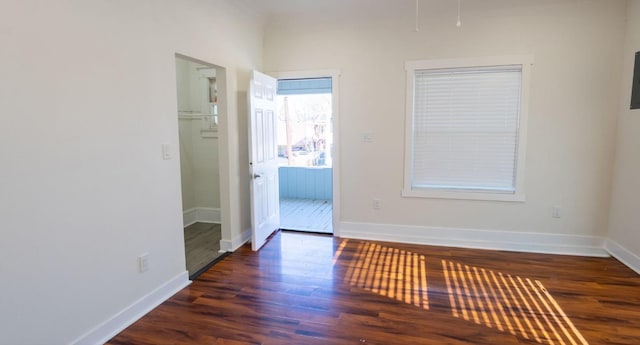 spare room featuring baseboards and wood finished floors