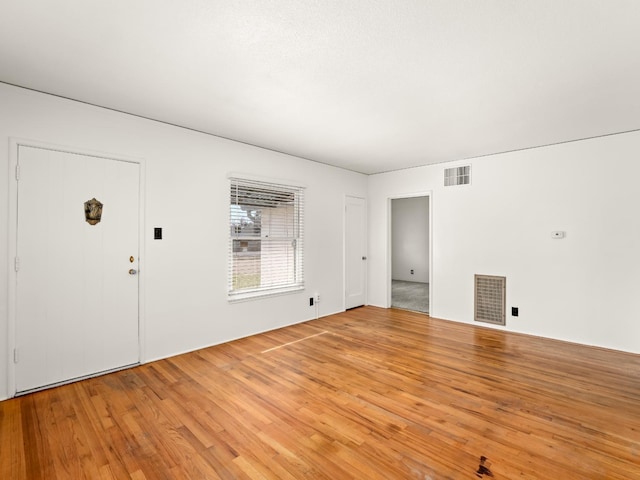 interior space with wood finished floors and visible vents