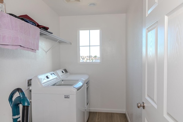 washroom featuring light wood-style floors, laundry area, baseboards, and separate washer and dryer