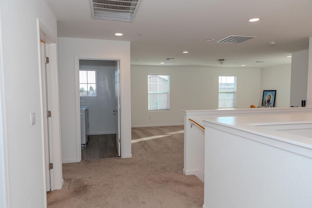 corridor featuring light carpet, washer / clothes dryer, visible vents, and recessed lighting