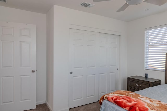 carpeted bedroom with a ceiling fan, a closet, visible vents, and baseboards