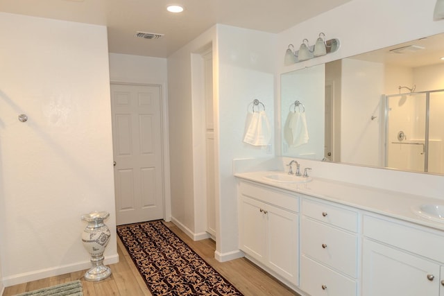 full bathroom featuring visible vents, a sink, and wood finished floors