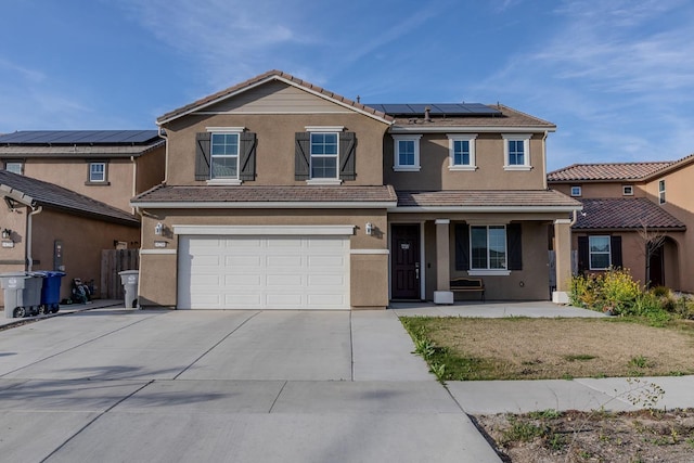 view of front of property with driveway, a garage, a tiled roof, roof mounted solar panels, and stucco siding