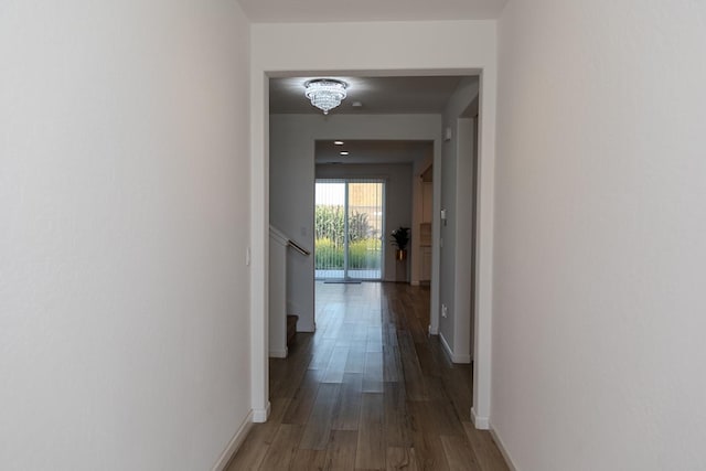 corridor featuring stairway, baseboards, and wood finished floors