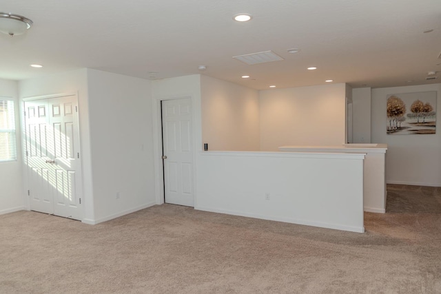 spare room featuring light carpet, baseboards, and recessed lighting