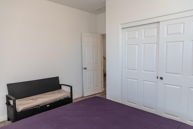 bedroom with carpet, a closet, visible vents, and baseboards