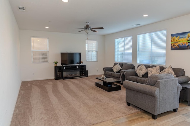 living room featuring baseboards, visible vents, ceiling fan, and recessed lighting