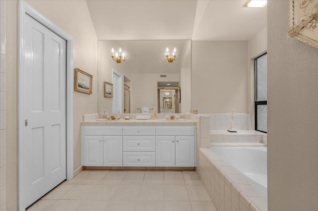 full bath with a garden tub, double vanity, an inviting chandelier, a sink, and tile patterned flooring