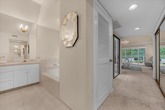 interior space featuring visible vents, vanity, a chandelier, tile patterned flooring, and a bath