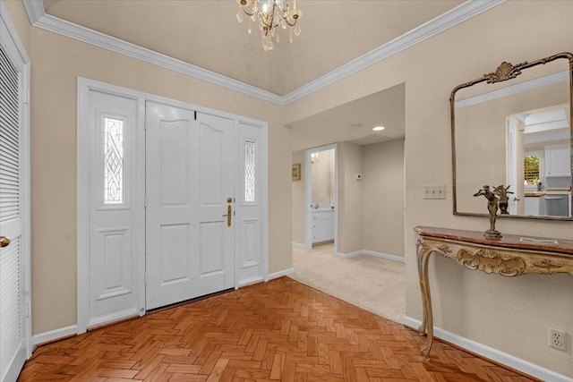 foyer entrance with a notable chandelier, baseboards, ornamental molding, and a wealth of natural light