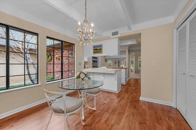 dining space with a notable chandelier, visible vents, light wood-type flooring, beamed ceiling, and baseboards