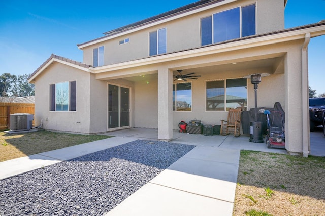 rear view of house featuring a ceiling fan, a patio, fence, central air condition unit, and stucco siding