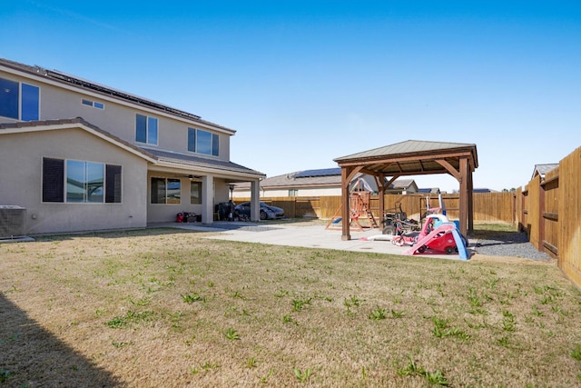 view of yard with a fenced backyard, a patio, a gazebo, and central AC unit