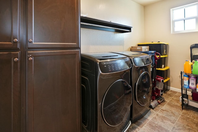 washroom with independent washer and dryer, cabinet space, and baseboards