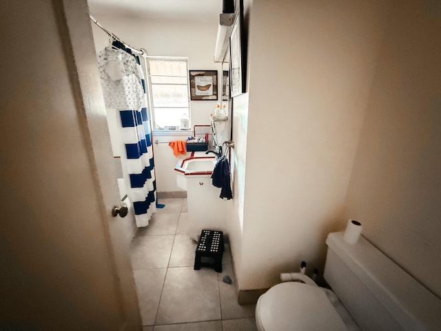 bathroom featuring a sink, tile patterned flooring, toilet, and a shower with curtain