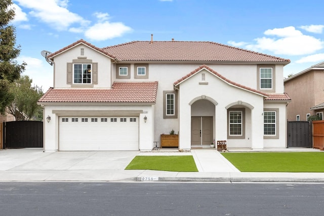 mediterranean / spanish house with concrete driveway, a gate, fence, and a tiled roof