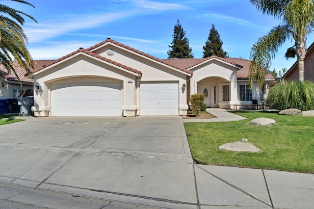 mediterranean / spanish-style home with an attached garage, a tile roof, concrete driveway, stucco siding, and a front yard