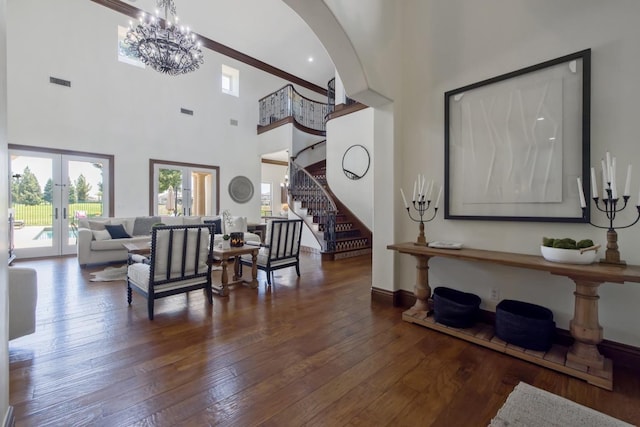 entryway with arched walkways, hardwood / wood-style flooring, visible vents, stairs, and french doors