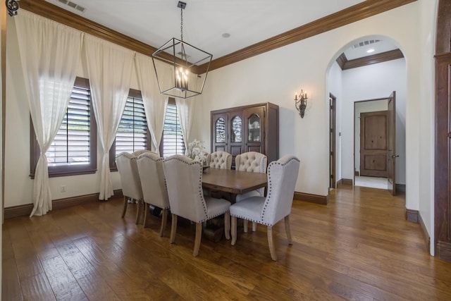 dining space with arched walkways, ornamental molding, dark wood-style flooring, and baseboards