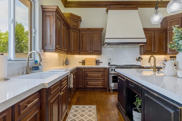 kitchen featuring light countertops, a sink, high end range, and custom exhaust hood