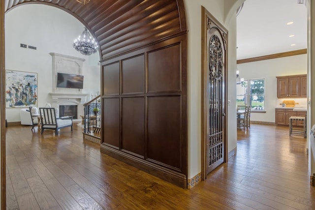 corridor featuring a notable chandelier, visible vents, arched walkways, and dark wood-style flooring