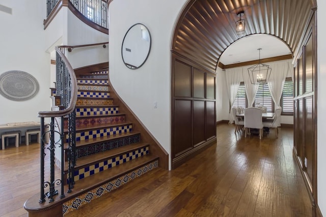 interior space with crown molding, wood-type flooring, and a notable chandelier