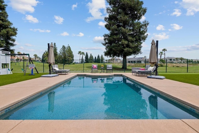 view of pool featuring a patio area, fence, and a yard