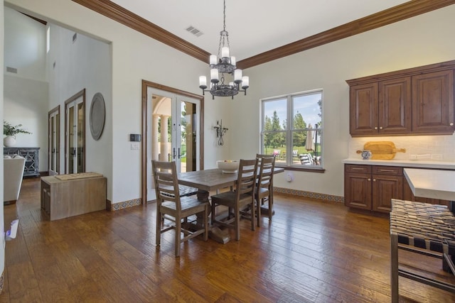 dining room with baseboards, crown molding, visible vents, and dark wood-type flooring