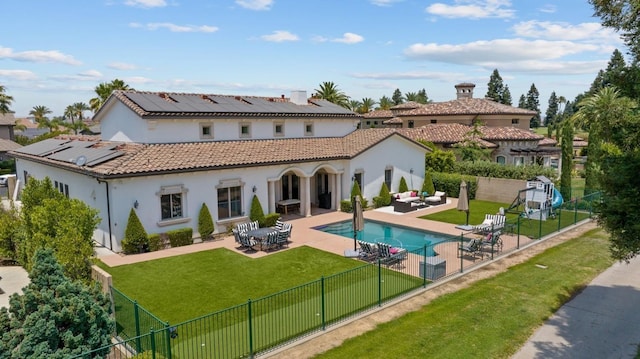 back of property featuring a tile roof, a yard, a patio, an outdoor hangout area, and a fenced backyard