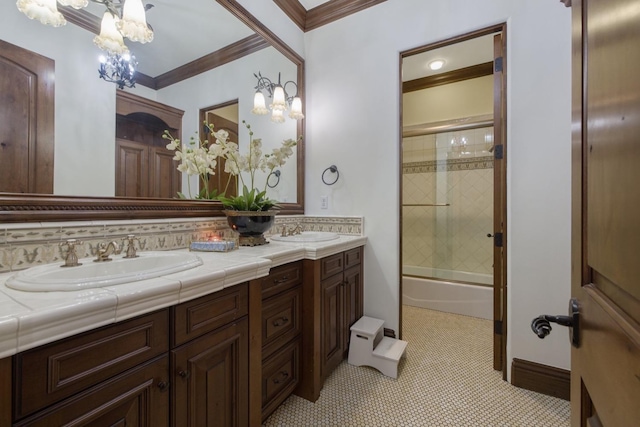 bathroom with double vanity, crown molding, bath / shower combo with glass door, and a sink