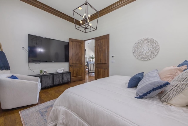 bedroom with ornamental molding, wood finished floors, and an inviting chandelier