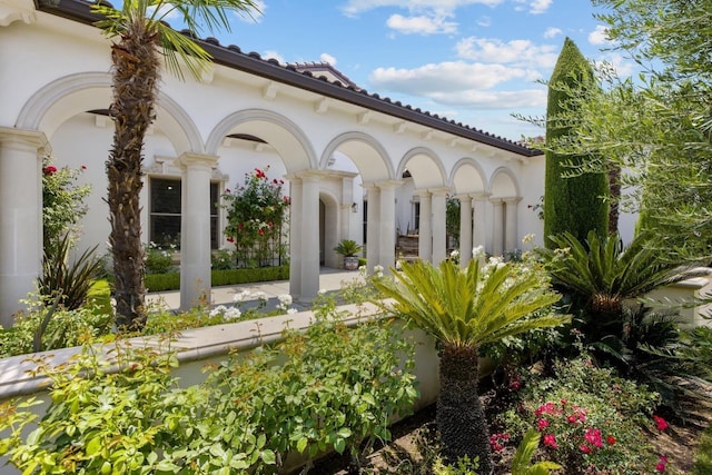 exterior space featuring a tile roof and stucco siding