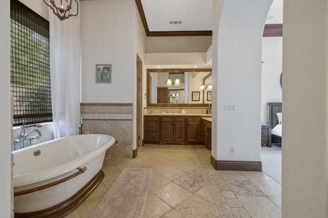 full bathroom with double vanity, visible vents, a freestanding bath, and an inviting chandelier