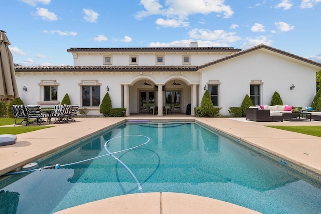 rear view of property featuring stucco siding, a patio area, an outdoor living space, and an outdoor pool