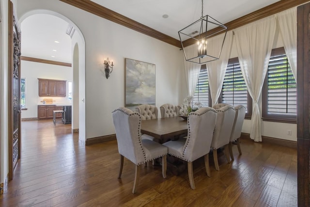 dining area with ornamental molding, arched walkways, dark wood-style flooring, and baseboards