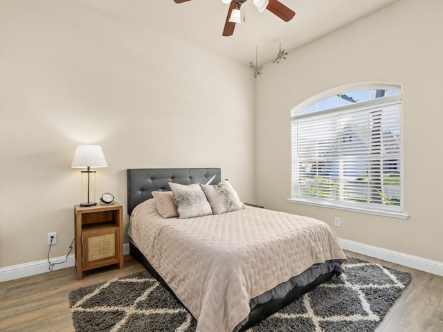 bedroom with wood finished floors, a ceiling fan, and baseboards