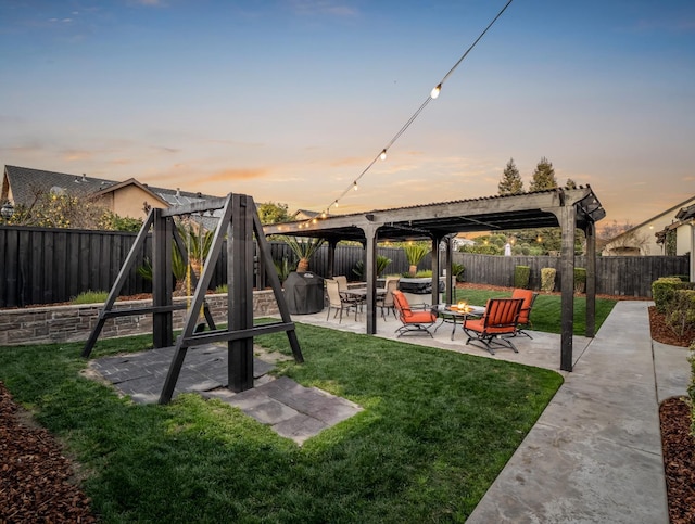 yard at dusk with a patio area, a fenced backyard, and a pergola