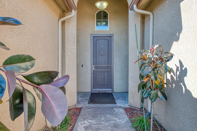 view of exterior entry featuring stucco siding