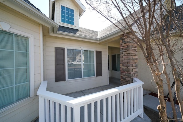 view of side of home with roof with shingles