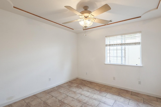 unfurnished room featuring a ceiling fan and baseboards