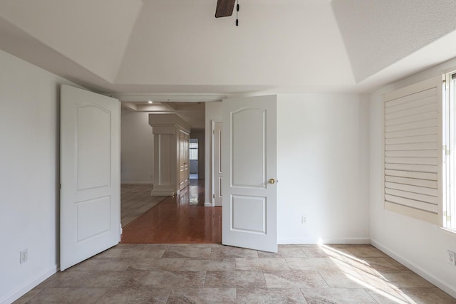 spare room with vaulted ceiling, ceiling fan, and baseboards