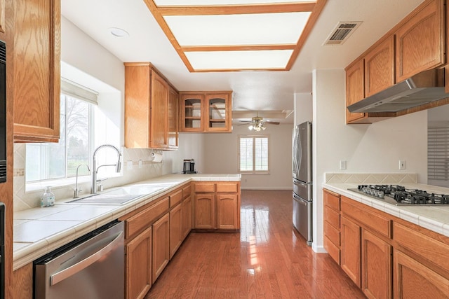 kitchen with appliances with stainless steel finishes, visible vents, under cabinet range hood, and tile countertops