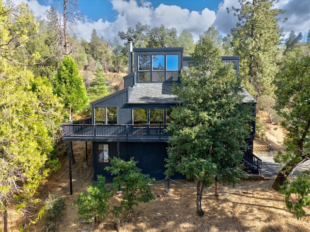 rear view of property with stairway and a wooden deck