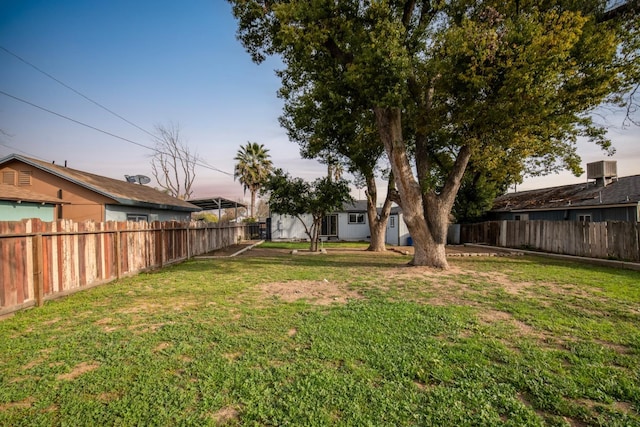 view of yard with a fenced backyard and central air condition unit