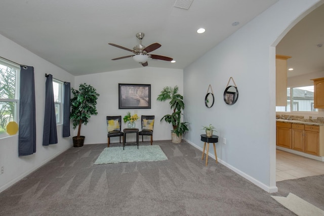 office space featuring arched walkways, light colored carpet, vaulted ceiling, and visible vents